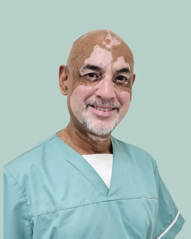 Dr Gasan Chetty, General Practitioner and Occupational Health Doctor at Belgrave PharmHealth, wearing teal clinical scrubs.